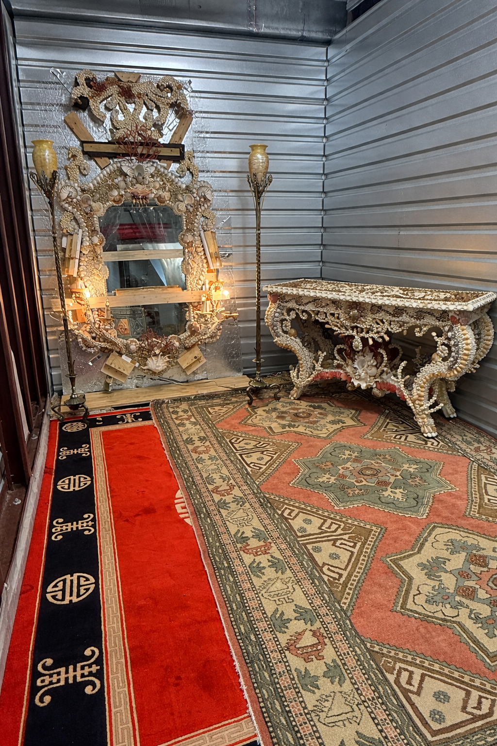 Palm Beach Estate Empire warehouse showcasing shell-encrusted grotto console, oriental rugs, and antique treasures